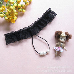 Black lace headband with a doll and yellow flowers on a pink background