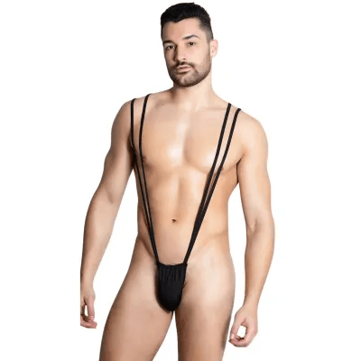 This image features a model wearing the Itspleazure Black Mankini Penis Pouch, a men's lingerie item. The pouch is black, free-size, and designed with multiple straps that provide a secure fit.