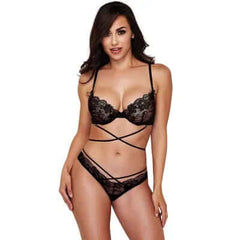 A woman wearing a black floral mesh lingerie set, including a bra and panties, with straps and lace detailing.