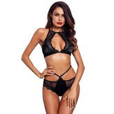 A woman wearing black halter neck floral women's lingerie with lace detailing.